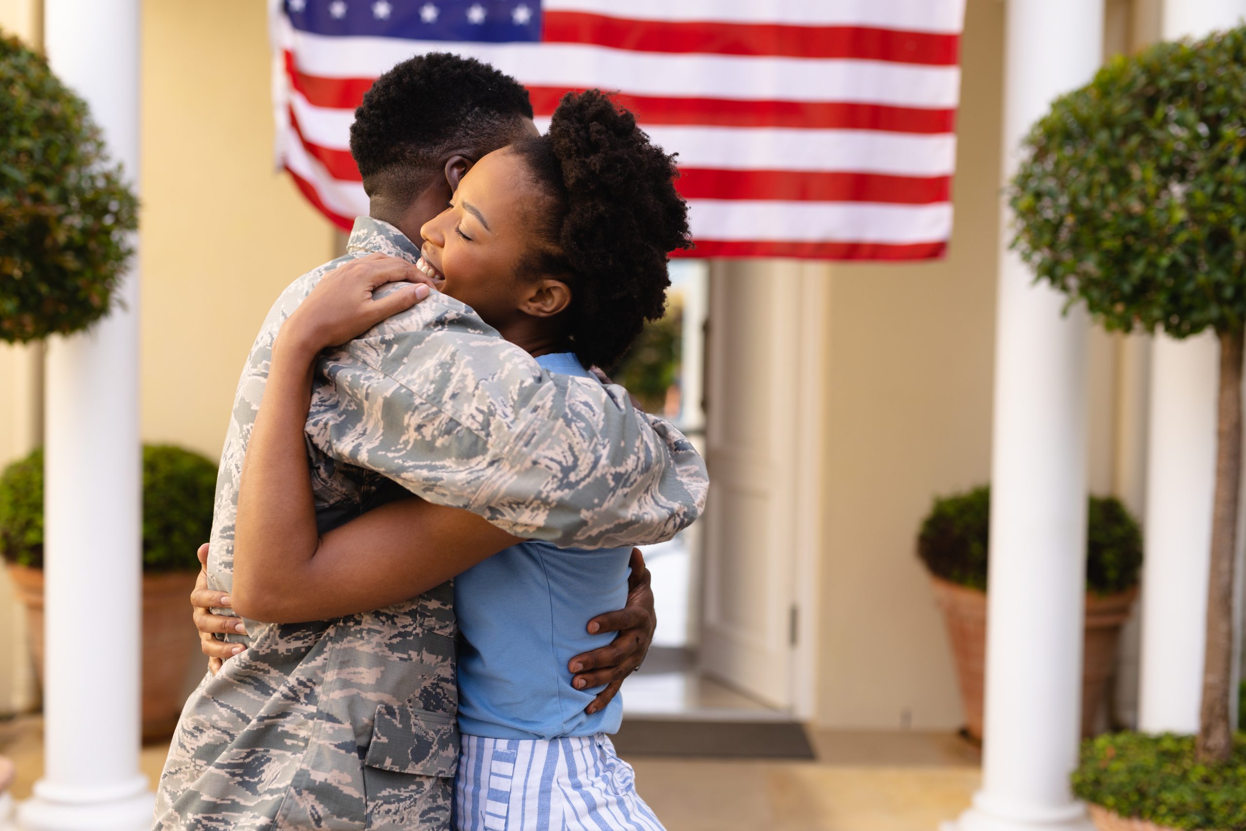 Military couple in front of a home